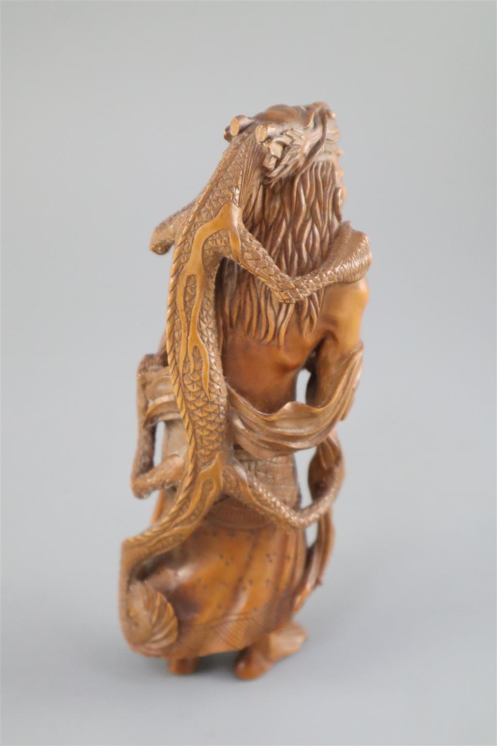 A fine Japanese boxwood okimono of the Sennin Handaka Sonja with a dragon clambering on his back, 19th century, signed Masakazu, 16.5cm